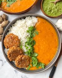 Dal Tadka — creamy spiced lentils served alongside fluffy rice and fresh green chutney